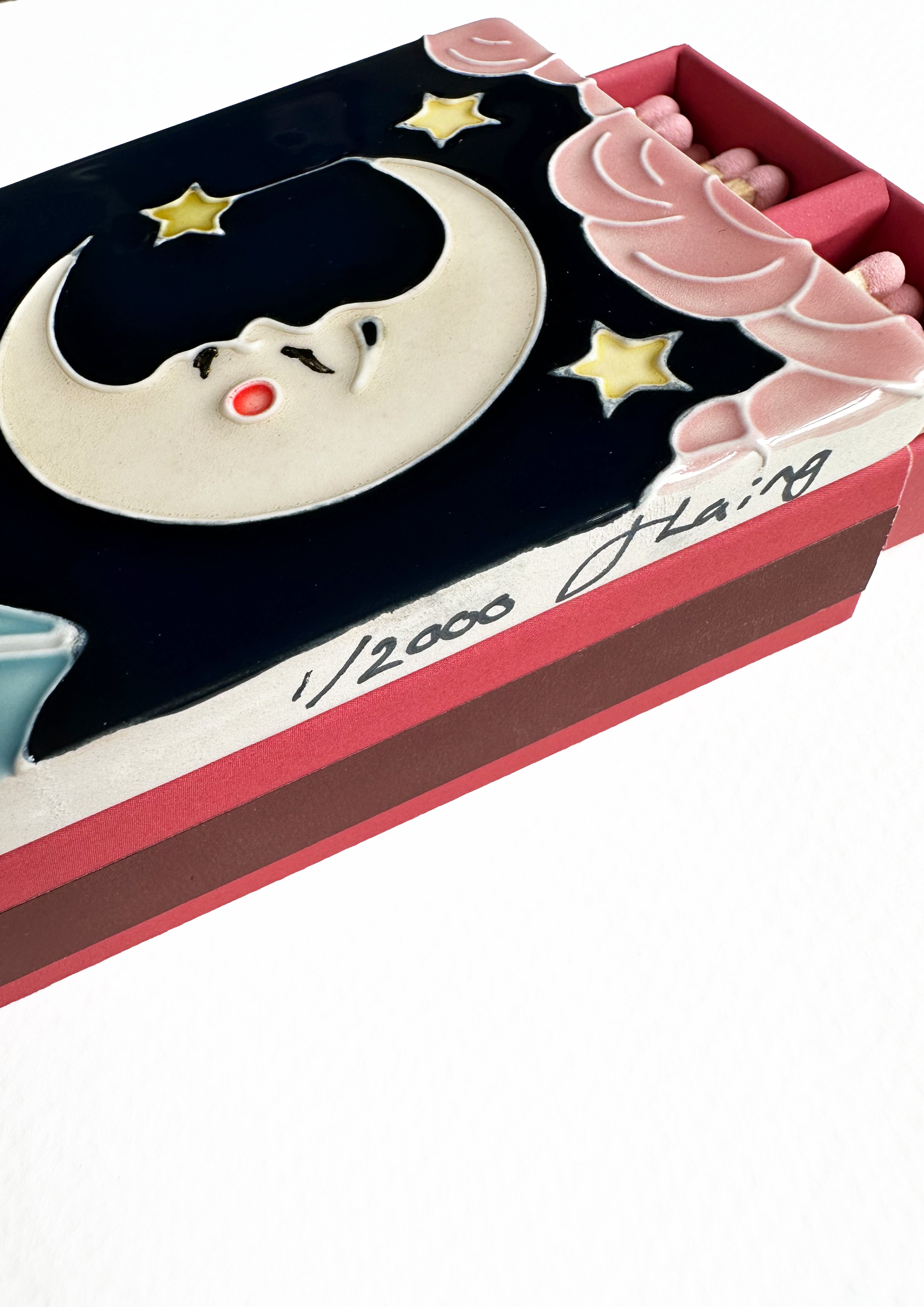 Bestselling luxury ceramic matchbox featuring The Moon Tarot card. The ceramic artwork sits atop a luxury card case with striker strip. Each box contains 40 navy coloured extra long safety matches. Made exclusively in England.